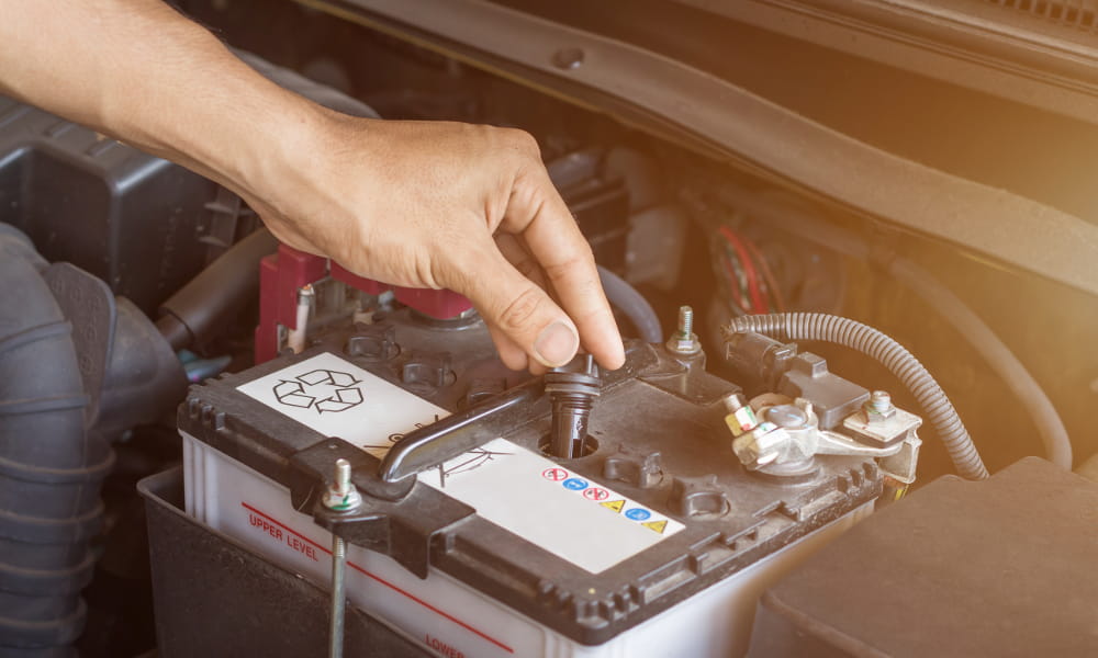 Bateria para nobreak: mecânico verificando uma bateria automotiva.